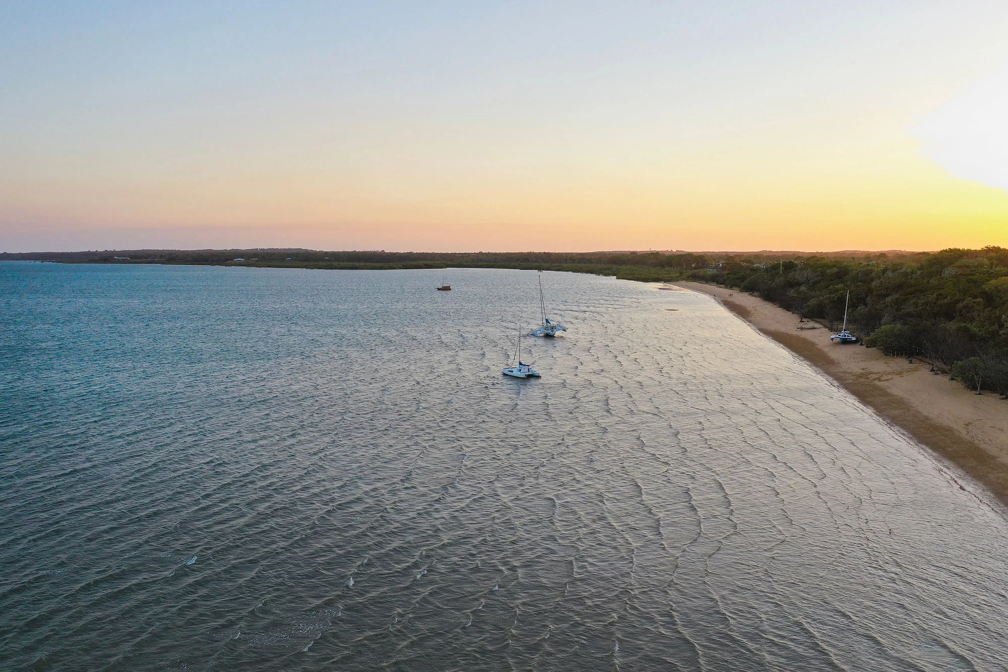 Small sailing boats on Hervey Bay at sunset